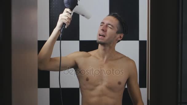 Young man drying his hair in bathroom — Stock Video