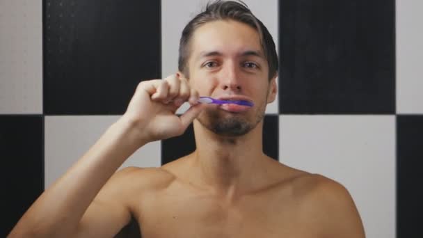 若い男がバスルームで歯を磨き — ストック動画