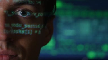 Adam programcı hacker yeşil kod karakterlerle portresi ile bir bilgisayar ekranında arka yüzünde yansıtacak