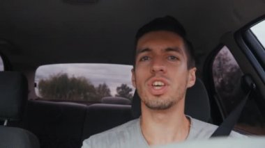 yakışıklı adam sürüş sırasında bir şarkı söyler