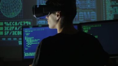 Erkek hacker programcı bir sanal gerçeklik kask programlama için kullanır. Bu geleceğin teknolojileri.