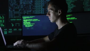 portre ile dolu veri merkezindeki bir bilgisayarda çalışan genç bir programcı görüntüleme ekranları