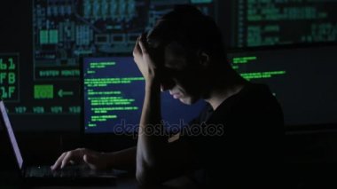 portre ile dolu veri merkezindeki bir bilgisayarda çalışan yorgun genç programcı görüntüleme ekranları