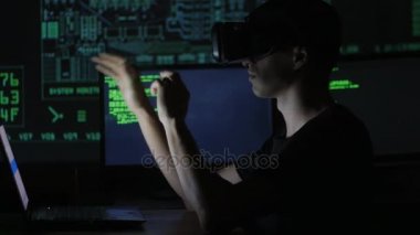 Erkek hacker programcı bir sanal gerçeklik kask programlama için kullanır. Bu geleceğin teknolojileri.