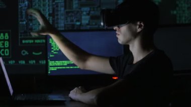 Erkek hacker programcı bir sanal gerçeklik kask programlama için kullanır. Bu geleceğin teknolojileri.