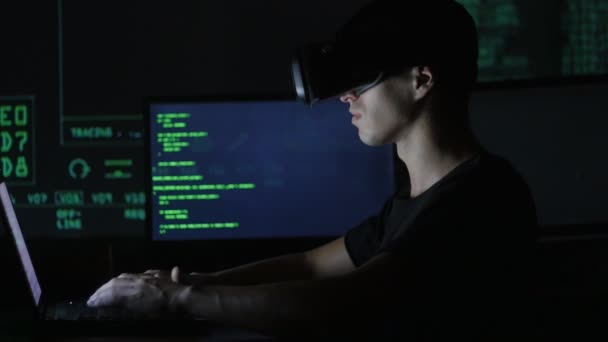 Erkek hacker programcı bir sanal gerçeklik kask programlama için kullanır. Bu geleceğin teknolojileri. — Stok video