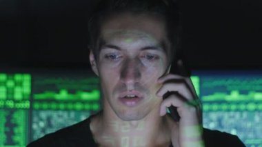 Hacker programcı göstermek perde ile dolu siber güvenlik Merkezi'ndeki telefonda konuşuyor.