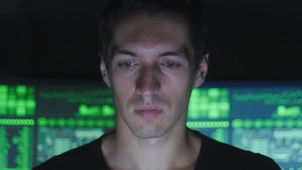 Programmeur pirate dans les lunettes travaille sur ordinateur dans le centre de cybersécurité rempli d'écrans d'affichage .