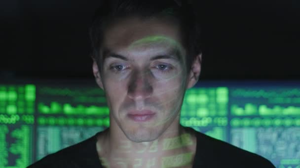 Programmeur pirate dans les lunettes travaille sur ordinateur dans le centre de cybersécurité rempli d'écrans d'affichage .