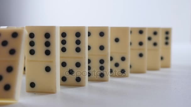 Weiße Dominosteine, die in einer Kettenreaktion fallen. Dominoeffekt — Stockvideo