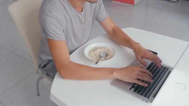 Ocupado hombre de negocios multitarea en la cocina trabajando en el ordenador portátil y comer, timelapse — Vídeos de Stock