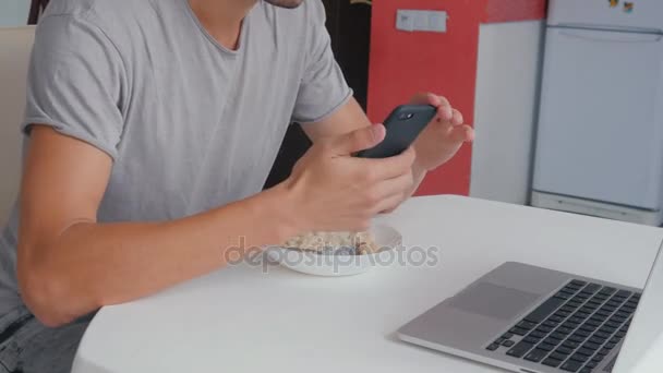 Drukke multitasking zakenman in de keuken bezig met laptop en eten, timelapse — Stockvideo