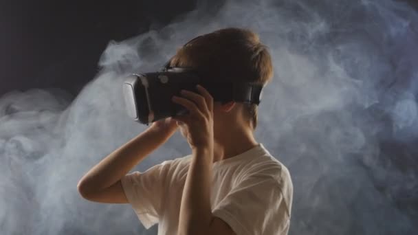 Jongen krijgt ervaring in het gebruik van Vr-headset in een rokerige donkere kamer — Stockvideo