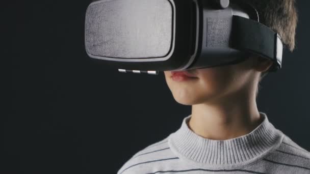 10-летний мальчик с крупным планом в шлеме виртуальной реальности. Опыт работы с VR 360 — стоковое видео