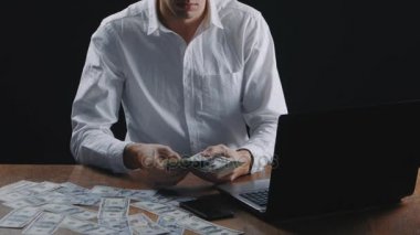 Genç işadamı Office masada oturan para sayma. Maaş veya kar kavramı.