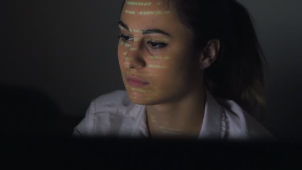 Jonge vrouwen schrobben trog computercode. Vrouwelijke gezicht met binaire code projecties — Stockvideo