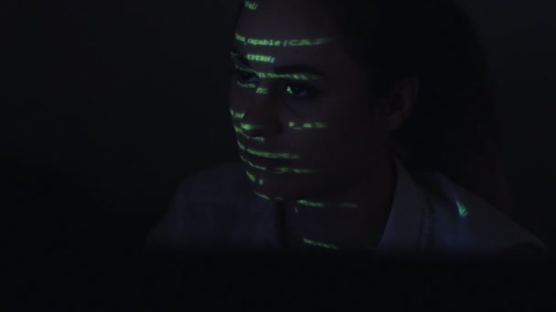 Les jeunes femmes frottent le code informatique. Visage féminin avec projections de code binaire 