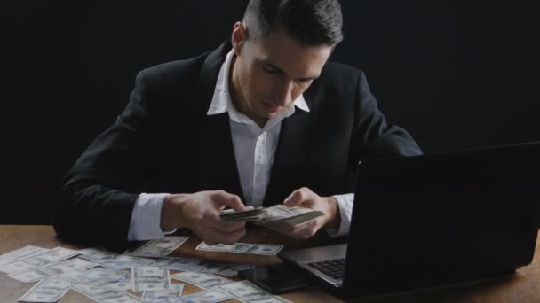 Junger erfolgreicher Geschäftsmann, der im Büro am Tisch Geld zählt. Konzept von Gehalt oder Gewinn. — Stockvideo