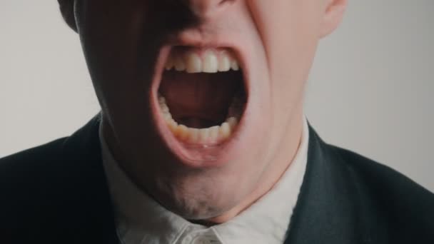 Zblízka naštvaný podnikatel křičí na bílém pozadí. — Stock video