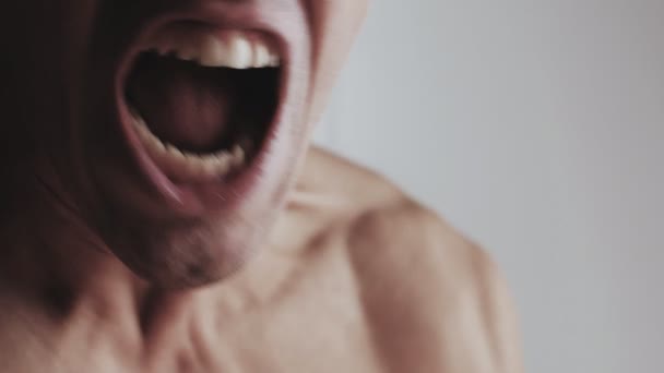 Mund eines wütenden Mannes, der auf weißem Hintergrund schreit. Gefahr Gewalt — Stockvideo