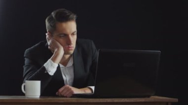 Karanlık Ofis Masası tarafından oturan sıkılmış iş adamı