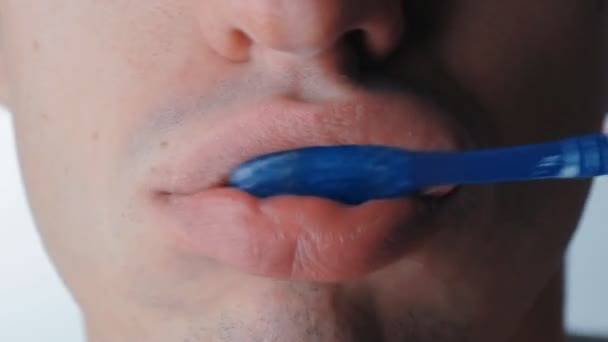 Extreme close up mans mouth as he brushes his teeth on isolated white background — Stock Video