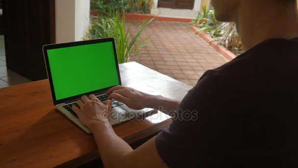 Ο άνθρωπος που εργάζεται στο φορητό υπολογιστή στο σπίτι με πράσινη οθόνη. Freelancer έργα στο σπίτι. — Αρχείο Βίντεο