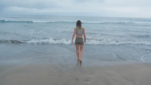 Retrato de una joven feliz corriendo cerca de las olas del océano — Vídeos de Stock