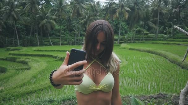 Young woman enjoying the nature in green tropical forest and make selfie with smartphone — Stock Video