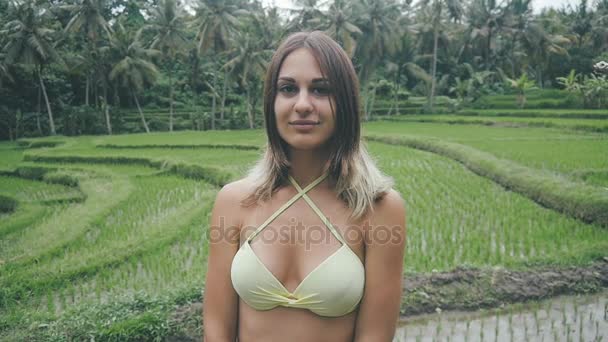 A háttérben a rizs mező Bali egy fiatal nő portréja — Stock videók