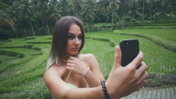 緑の熱帯林とスマート フォンで作る selfie で自然を楽しんでいる若い女性 — ストック動画