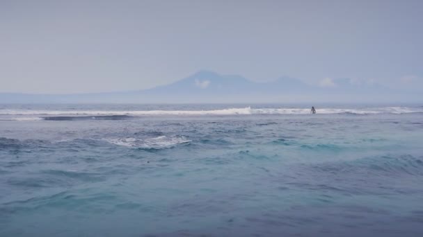 Vacker blå havets vågor och ett berg i bakgrunden i Slow Motion — Stockvideo