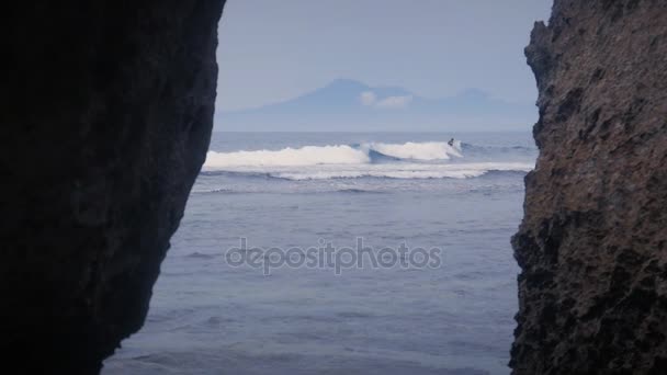 Hermosas olas del océano azul y una montaña al fondo en cámara lenta — Vídeos de Stock