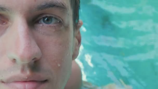 Gros plan portrait de beau jeune homme heureux relaxant dans la piscine — Video