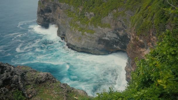 海洋波石の崖の上。インドネシア、バリ島の熱帯のビーチの空中の平面図です。スローモーション — ストック動画