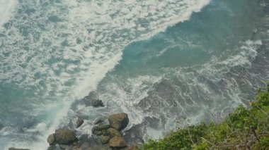 Okyanus dalgaları taş uçurumlarda kırma. Tropikal Beach Bali, Endonezya Hava üstten görünüm. Ağır çekim