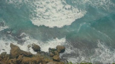 Okyanus dalgaları taş uçurumlarda kırma. Tropikal Beach Bali, Endonezya Hava üstten görünüm. Ağır çekim