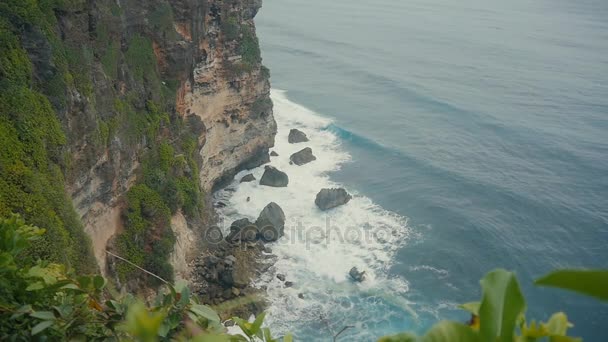 Ondas oceânicas a rebentar nos penhascos de pedra. Vista aérea superior da praia tropical Bali, Indonésia. Movimento lento — Vídeo de Stock
