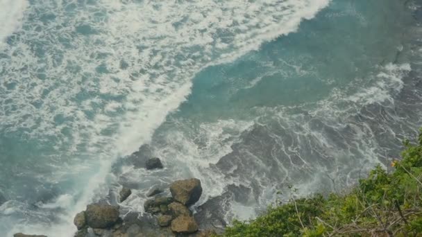 Óceáni hullámok feltörése a kő sziklák. Top Légifelvételek a Tropical beach, Bali, Indonézia. Lassú mozgás — Stock videók