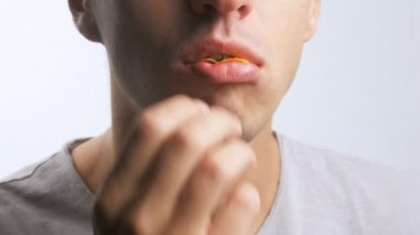 genç bir adam Close-Up patates cipsi zevk ile beyaz bir arka plan üzerinde yiyor.