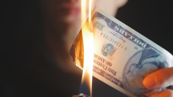 Yakın çekim adam bir dolarlık banknot karanlık bir arka planda yakar. — Stok video
