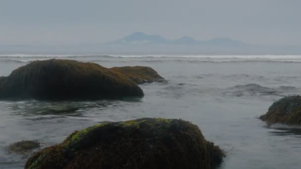 Onde oceaniche sullo sfondo su una bellissima riva rocciosa. Le pietre guardano fuori dall'acqua. Scadenza temporale — Video Stock