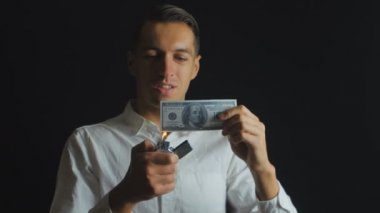 adam 100 dolar karanlık bir arka planda yakar.