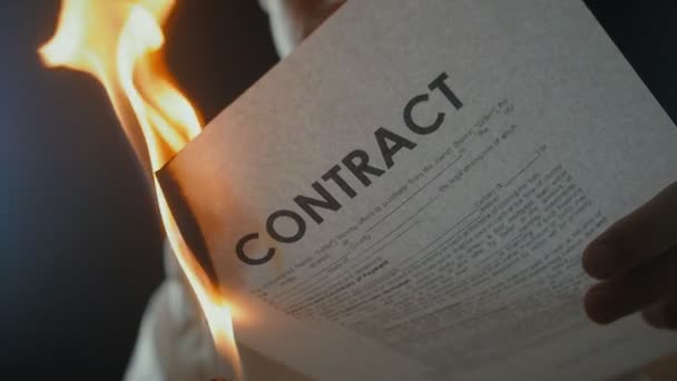 Um grande plano de um homem queima um documento contratual. Destruição de títulos. Interrupção de um acordo — Vídeo de Stock