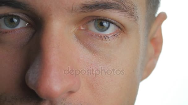 Zbliżenie się młody człowiek oko patrząc w aparat na odizolowanym białym tle — Wideo stockowe