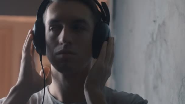 Primer plano de Joven con auriculares escuchando música — Vídeo de stock