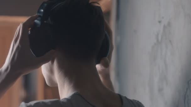 Close up van jonge man met een koptelefoon muziek luisteren — Stockvideo