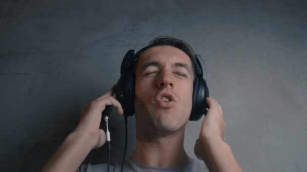 Mladý muž se sluchátky, poslech hudby a zpěvu — Stock video