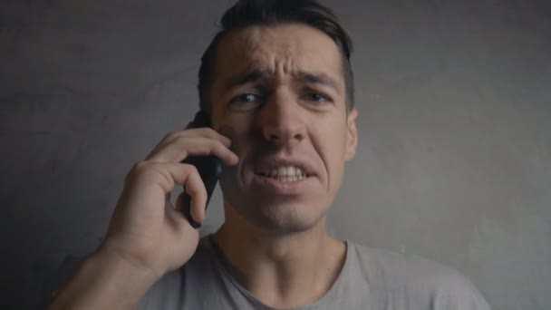 Een boze man schreeuwt naar de telefoon — Stockvideo