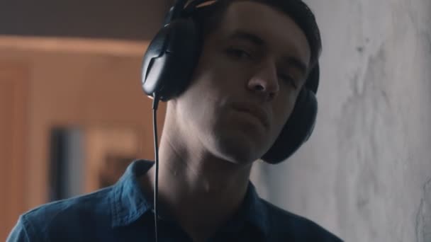 Junger Mann mit Kopfhörern hört Musik — Stockvideo
